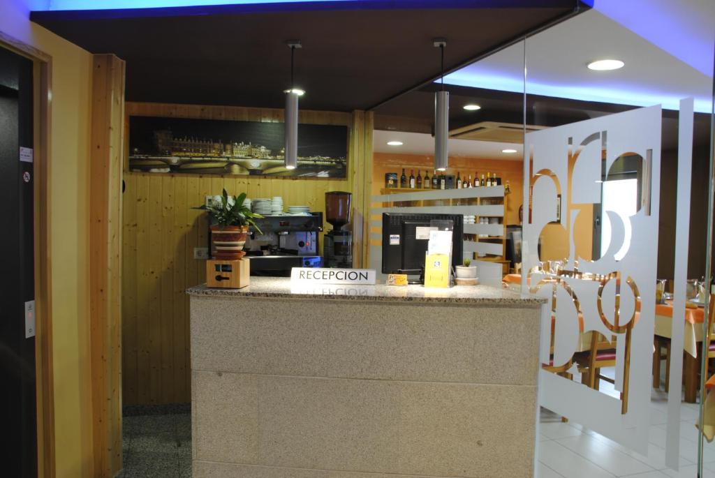 a restaurant with a counter in the middle at Hotel Alegría in Baños de Montemayor