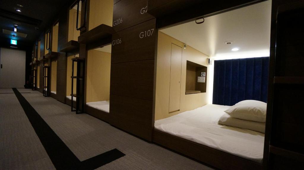 a row of bunk beds in a room at The Bed and Spa (male only) in Tokorozawa