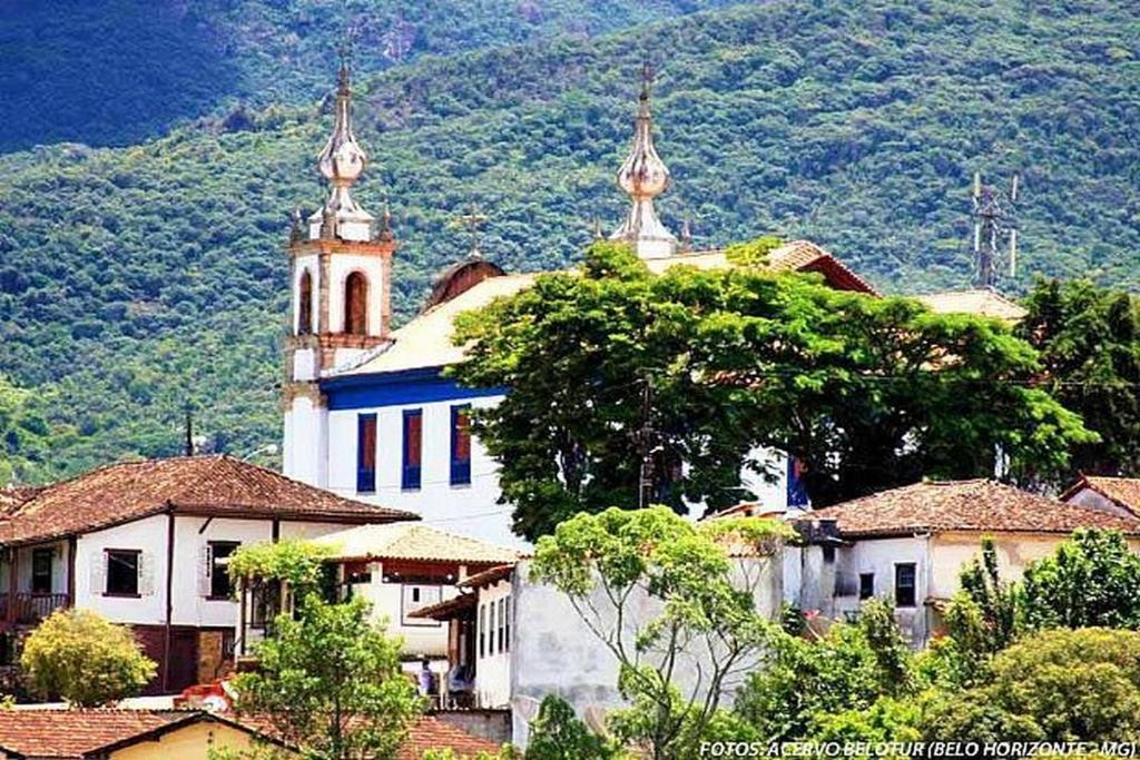 une église avec deux tours au sommet d'un village dans l'établissement Rez Home Catas Altas, à Catas Altas