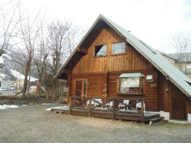 a large wooden cabin with a gambrel roof at Log Cottage Villa Happo in Hakuba