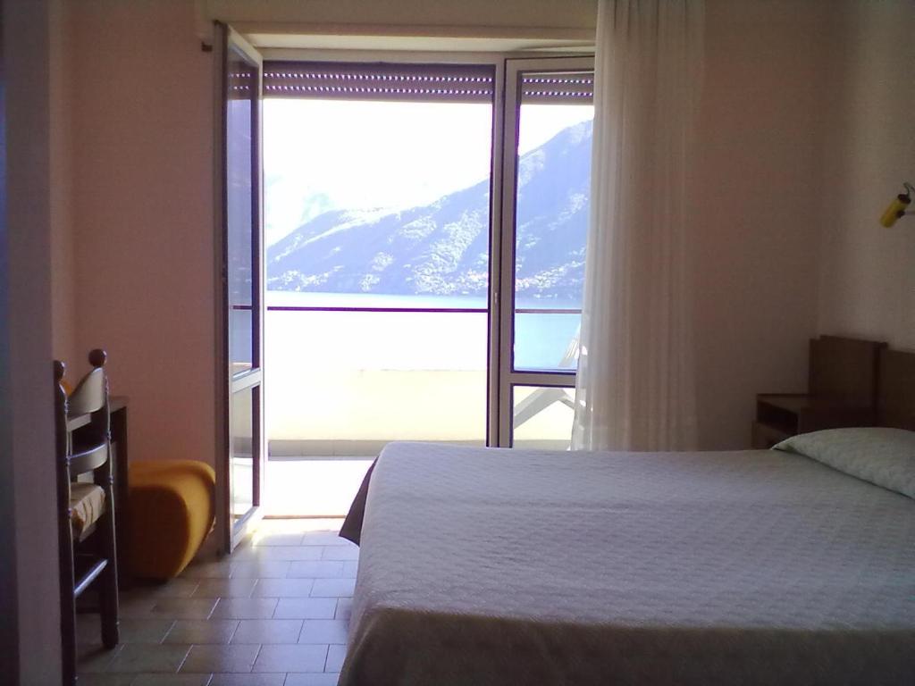 a bedroom with a bed and a view of a mountain at Hotel Glavjc in Torno