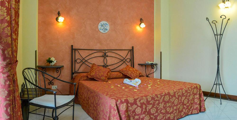 1 dormitorio con 1 cama y 1 silla en Hotel A Pinnata en Lipari