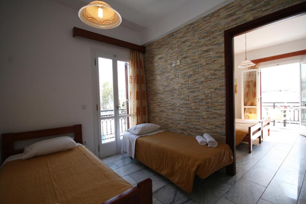 a bedroom with two beds and a brick wall at Iliovasilema in Naxos Chora