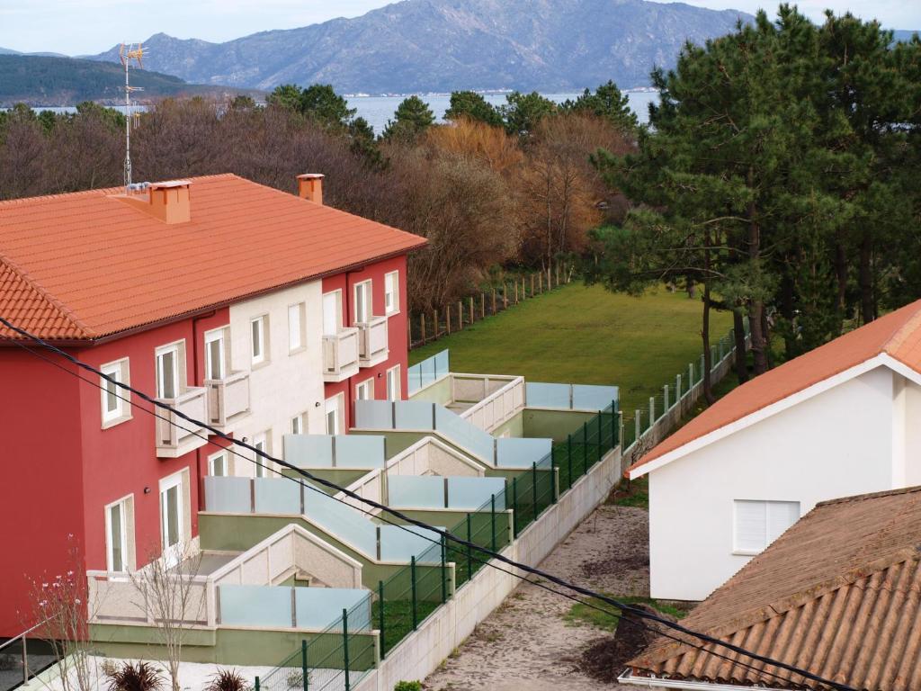 eine Reihe von Häusern mit einem Zaun und einem Hof in der Unterkunft Apartamentos VIDA Finisterre in Kap Finisterre