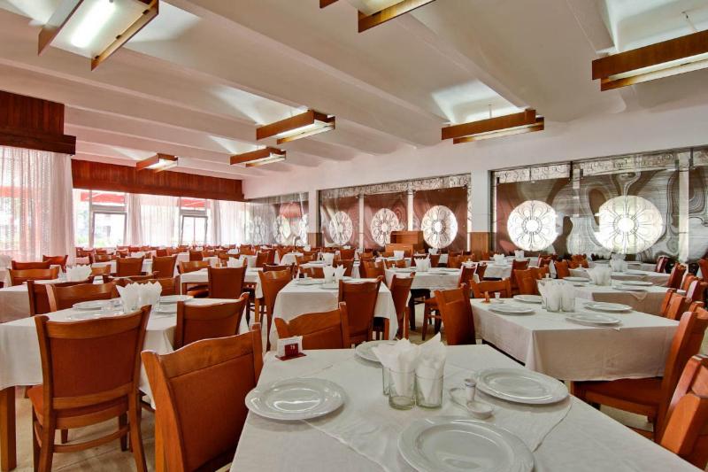 a dining room with white tables and chairs at Hotel Prahova in Saturn