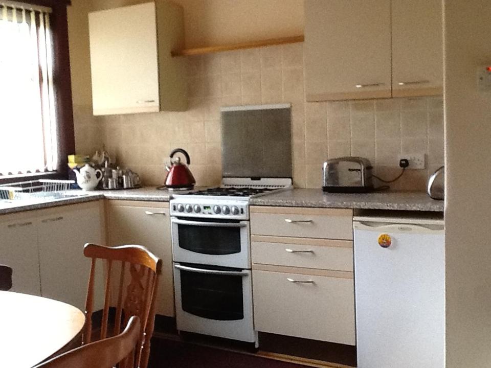 cocina con fogones blancos y fregadero en Rutland cottage, en Largs