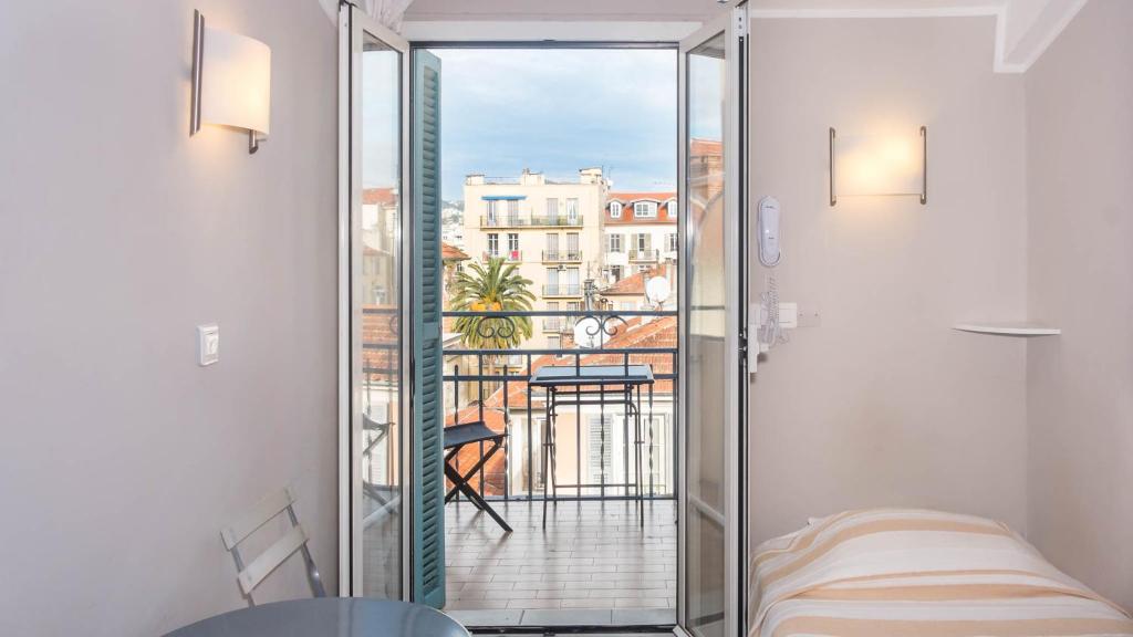 a room with a view of a balcony with a bed at Hotel Solara in Nice