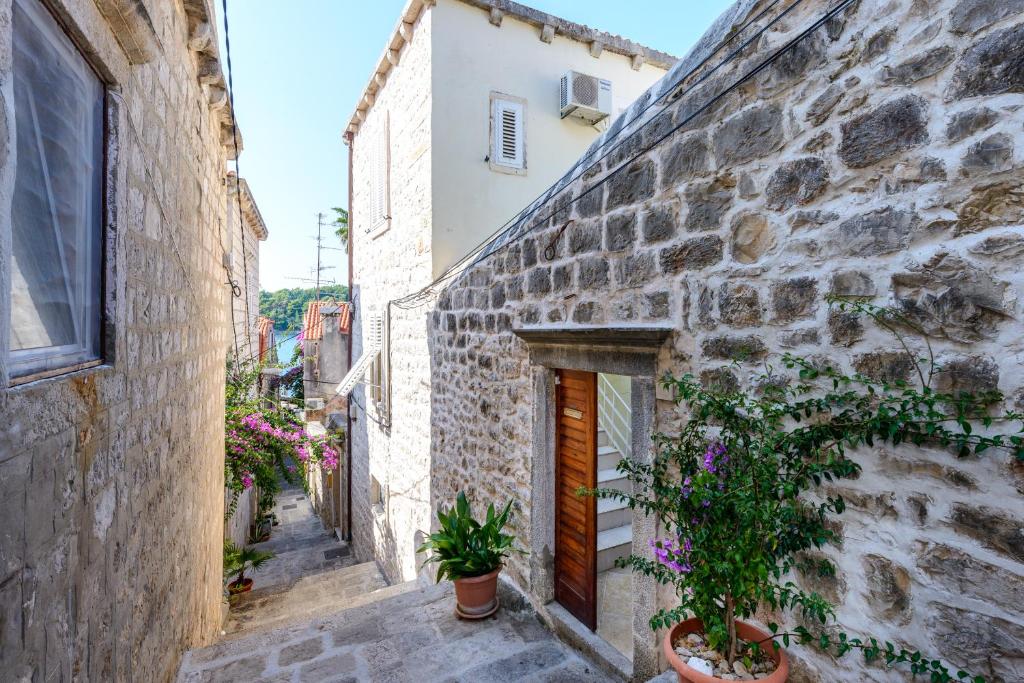 an alley with potted plants and a building at Apartments Villa Eta in Cavtat