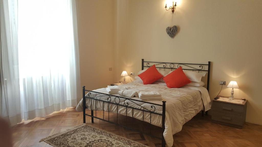 um quarto com uma cama com almofadas vermelhas em Garden Suite em Génova