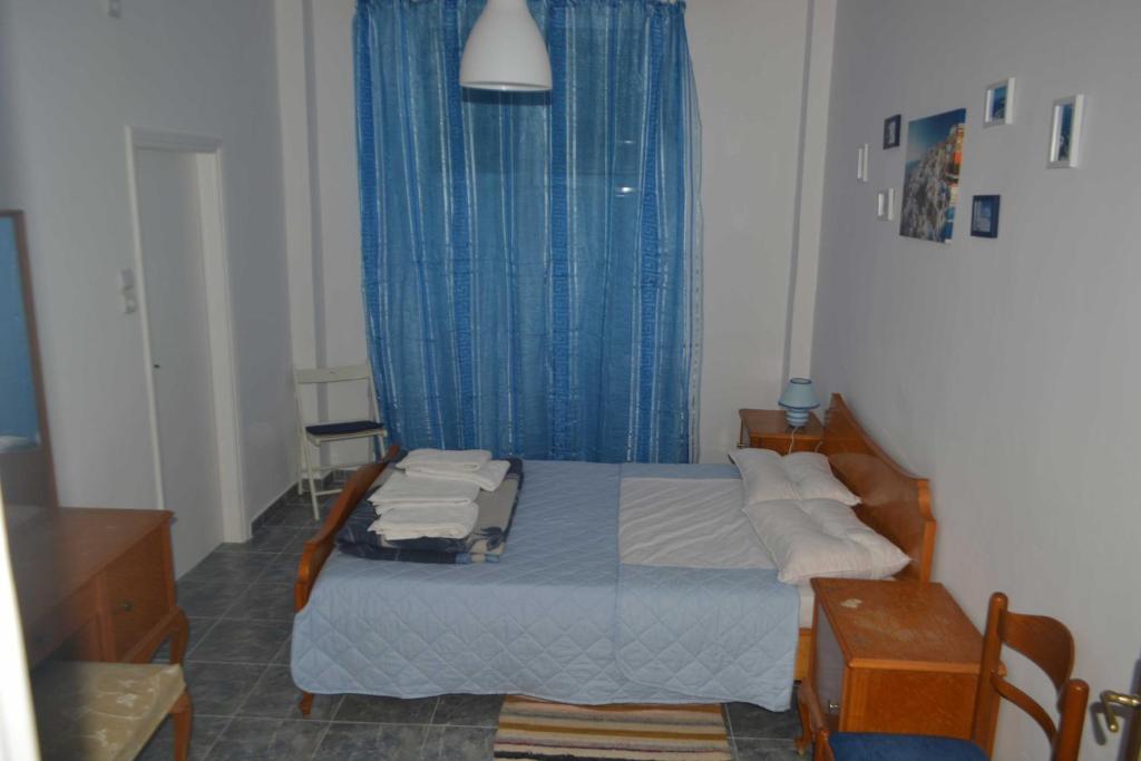 アテネにあるCosy apartment Acropolis Point 2のベッドルーム1室(青いカーテン付きのベッド1台付)