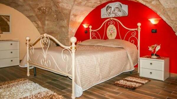 アッリステにあるCasa della Nonnaの赤い壁のベッドルーム1室(白いベッド1台付)