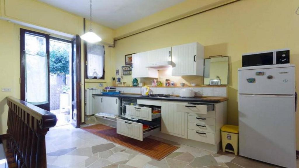 una cucina con armadietti bianchi e frigorifero bianco di Apartment Pink21 a Firenze