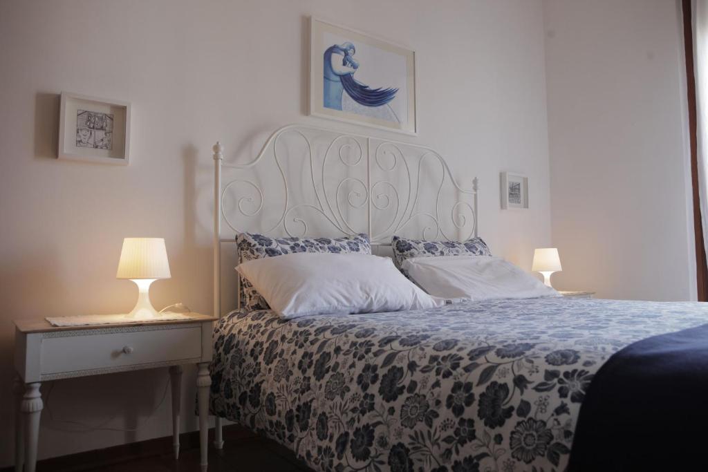 a bedroom with a bed and a table with lamps at Goga&Romeo in Pesaro