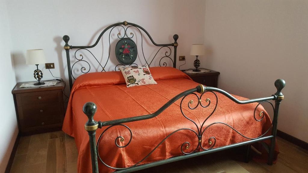 Cigognola的住宿－B&B Monteguzzo，一张带橙色毯子和2个床头柜的床