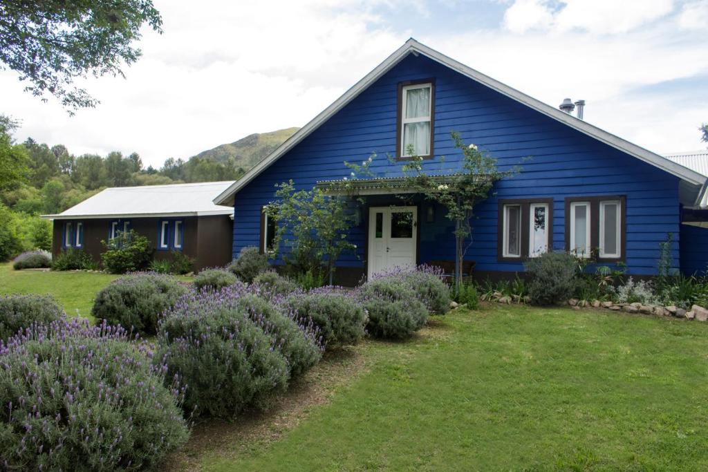 una casa blu con un giardino di fronte di Chacra La Invernada Pequeño Hotel de Campo a Villa Giardino
