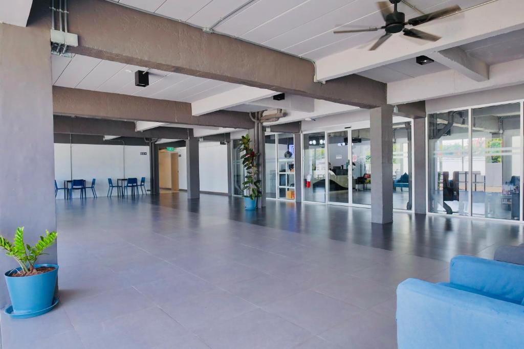 A spacious, open lobby with glass-fronted rooms and ceiling fans.