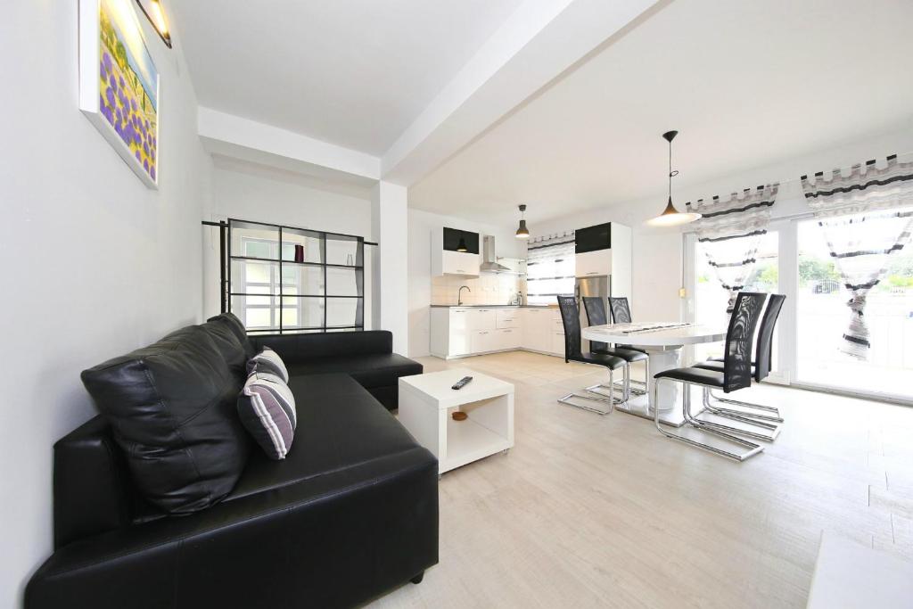 uma sala de estar com um sofá preto e uma mesa em Apartments Matkovic em Sveti Filip i Jakov