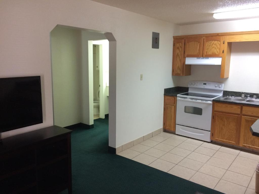 a kitchen with wooden cabinets and a white stove top oven at Travel Inn & Suites in Atlanta