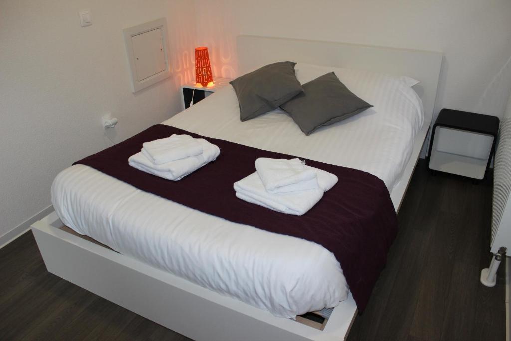sypialnia z łóżkiem z dwoma ręcznikami w obiekcie Résidence Hôtelière Louise w Strasburgu