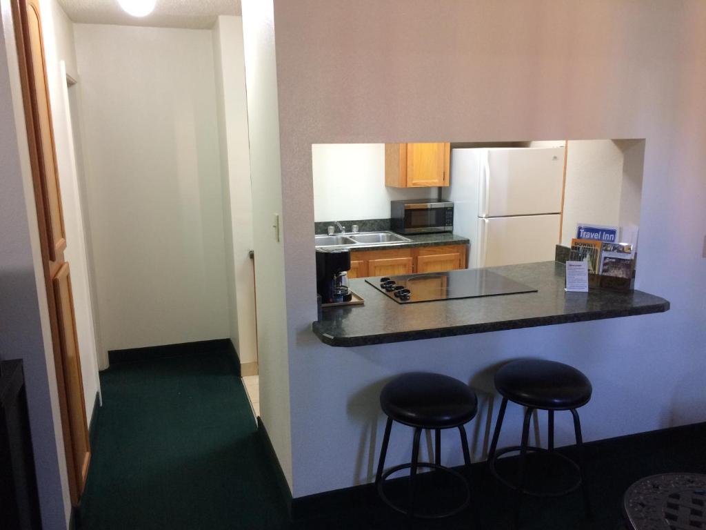 a small kitchen with a counter and two stools at Travel Inn & Suites in Atlanta