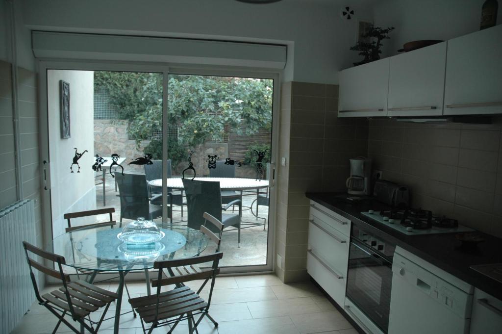 une cuisine avec une table en verre avec des chaises et une salle à manger dans l'établissement La Palma, à Ajaccio