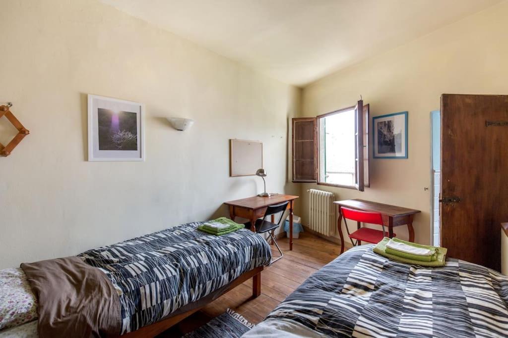 1 dormitorio con 2 camas, escritorio y mesa en Atmosfere Rinascimentali en Florence