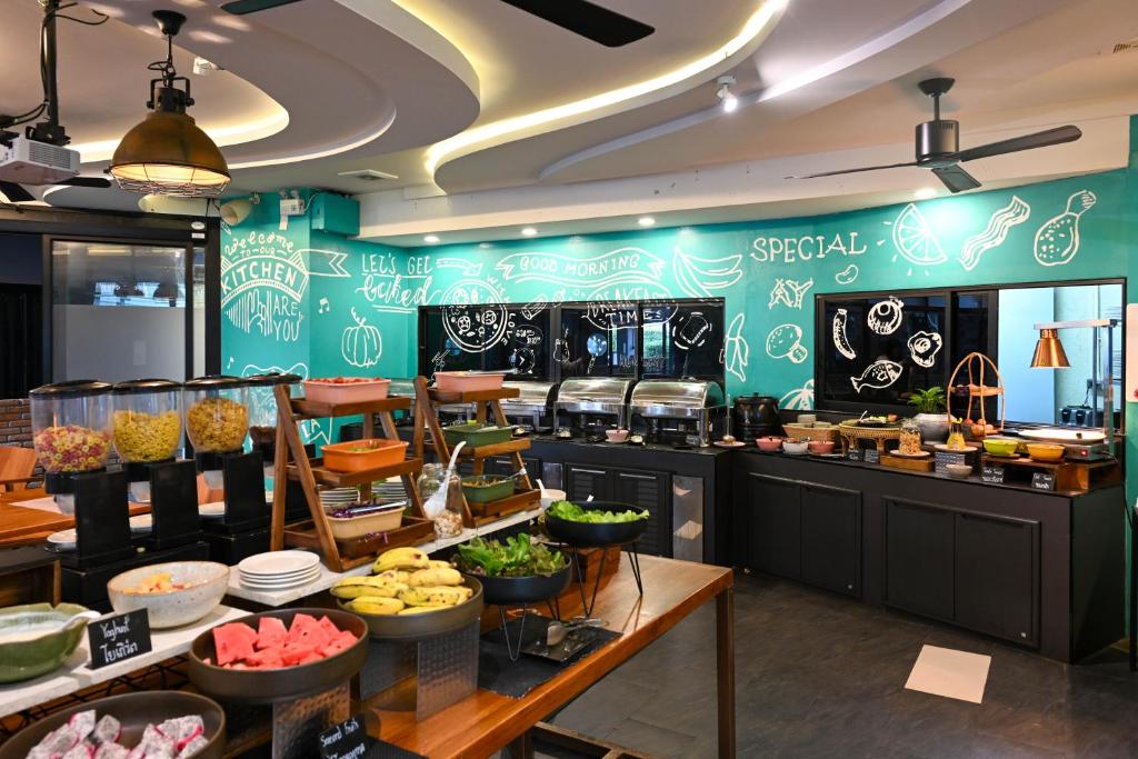 A buffet breakfast counter with cereals, fruit, hot dishes and drinks.