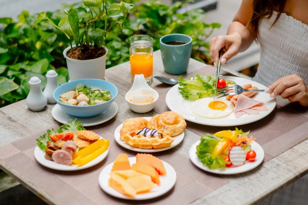 A breakfast table with eggs, fruit, pastries, soup, juice and coffee.