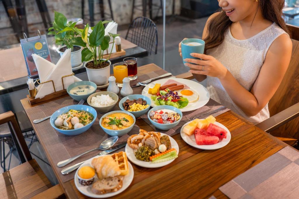 A seated breakfast spread with multiple dishes, fruit, pastries and drinks.