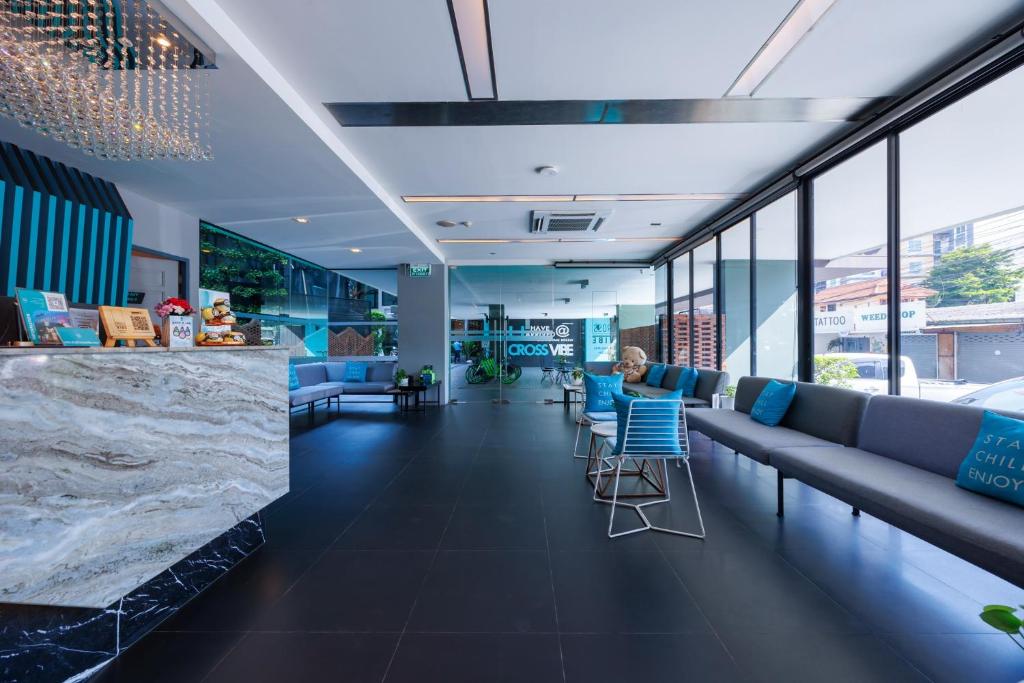 A modern lobby with a marble reception counter, lounge seating and large windows.