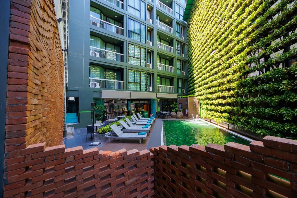 A courtyard view of the pool framed by hotel buildings and brickwork.