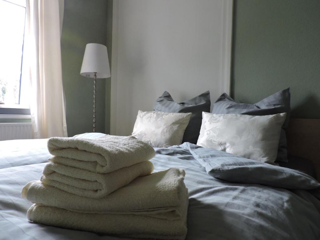 una pila de toallas sentadas encima de una cama en Altes Pastorat, en Barmstedt