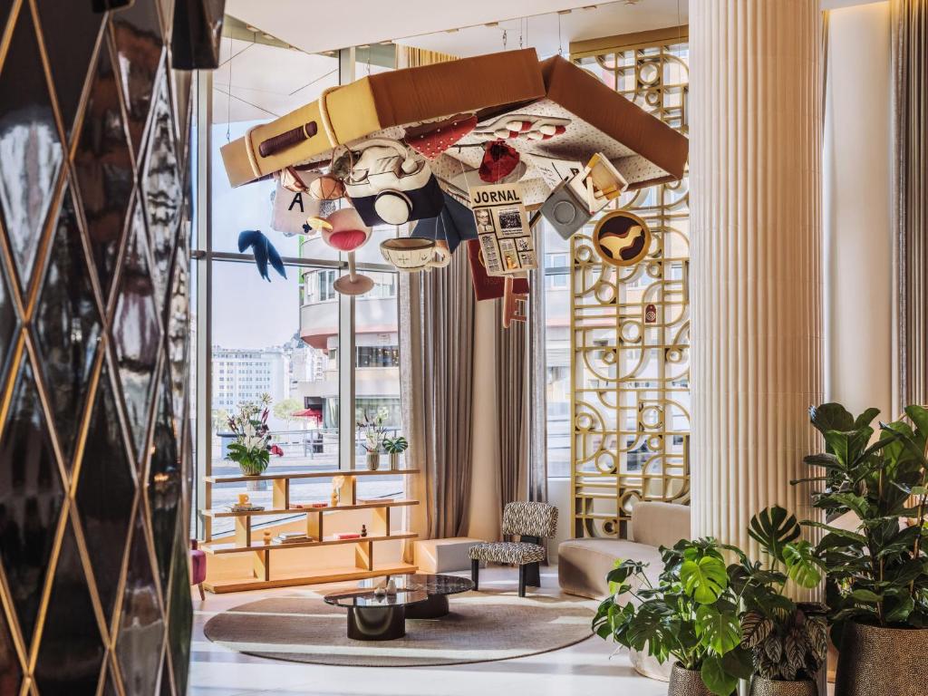 A bright lounge area beside large windows, styled with art and upholstered seating.