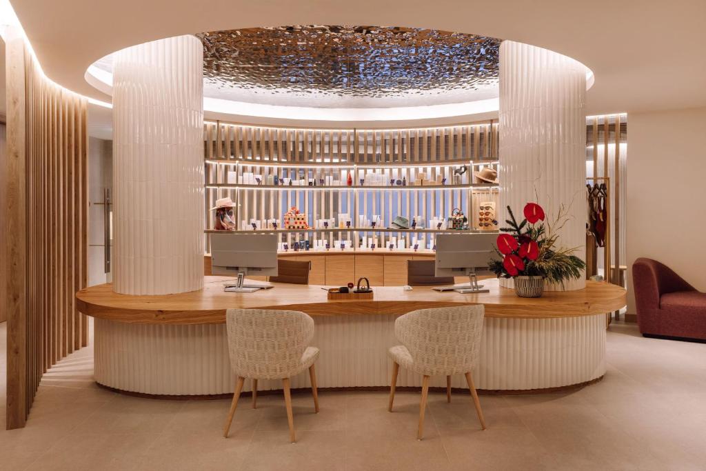 A curved reception and bar counter with two guest workstations.