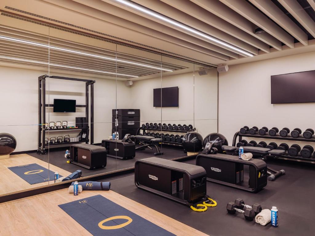 A bright mirrored fitness room combines free weights with functional-training equipment.