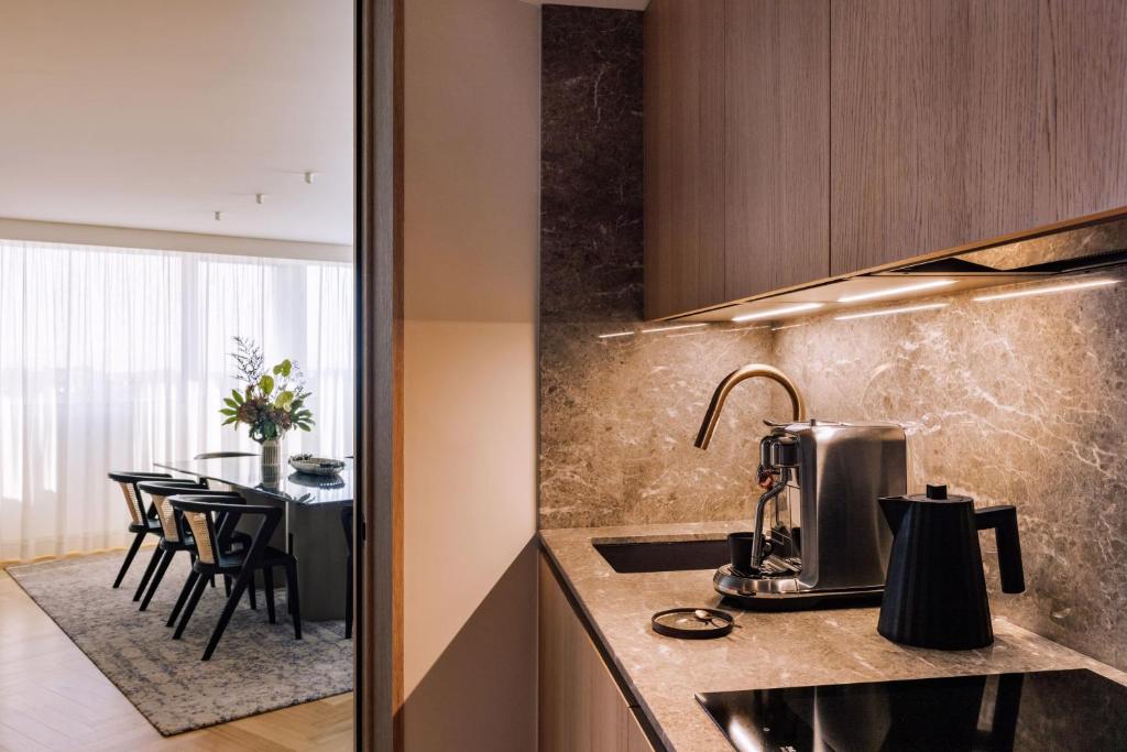 A compact kitchenette beside a dining area, equipped for coffee and light preparation.