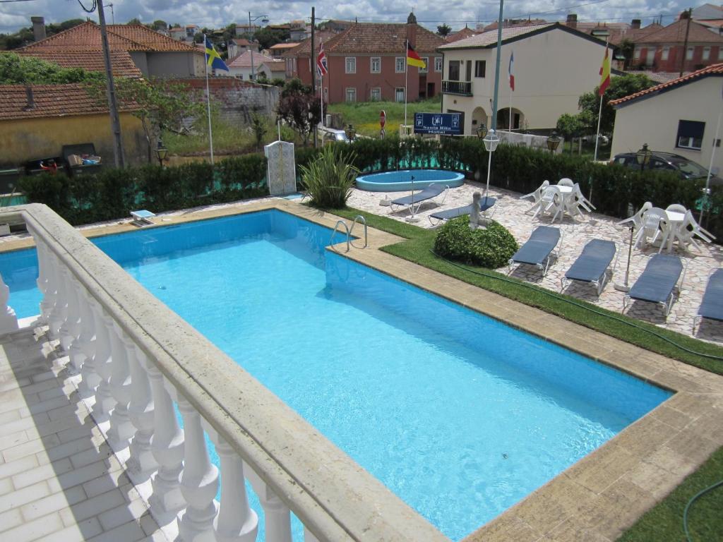 una gran piscina con sillas y una piscina en Hotel Santa Rita, en Monte Real