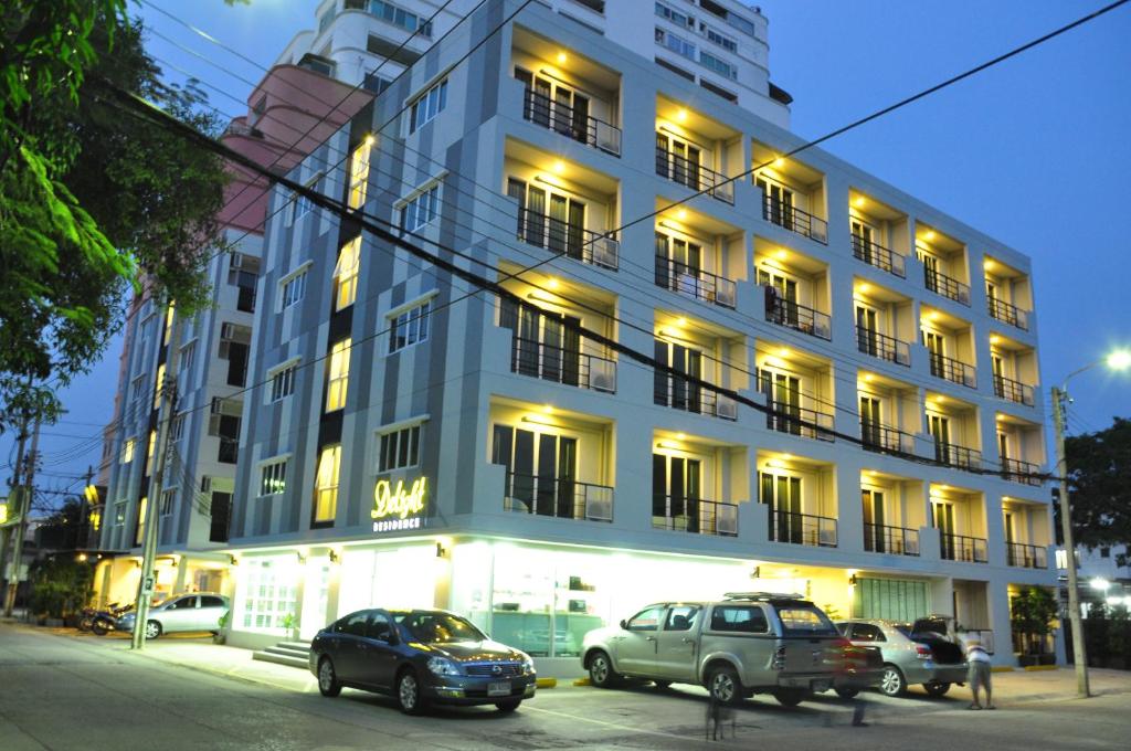 a large building with cars parked in front of it at Delight Residence in Bangkok
