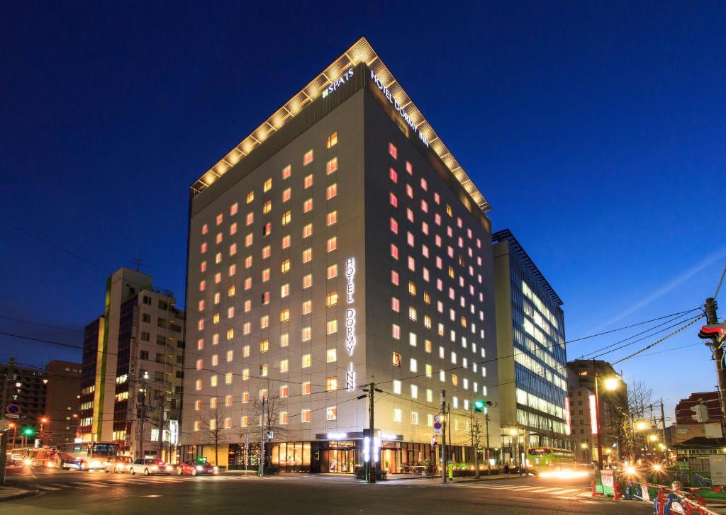 a large building on a city street at night at Dormy Inn Kumamoto Natural Hot Spring in Kumamoto