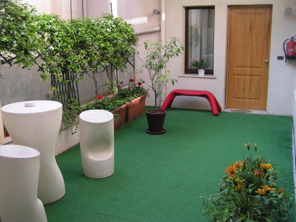um pátio com um piso verde e um banco vermelho em Albergo Verdi em Pádua