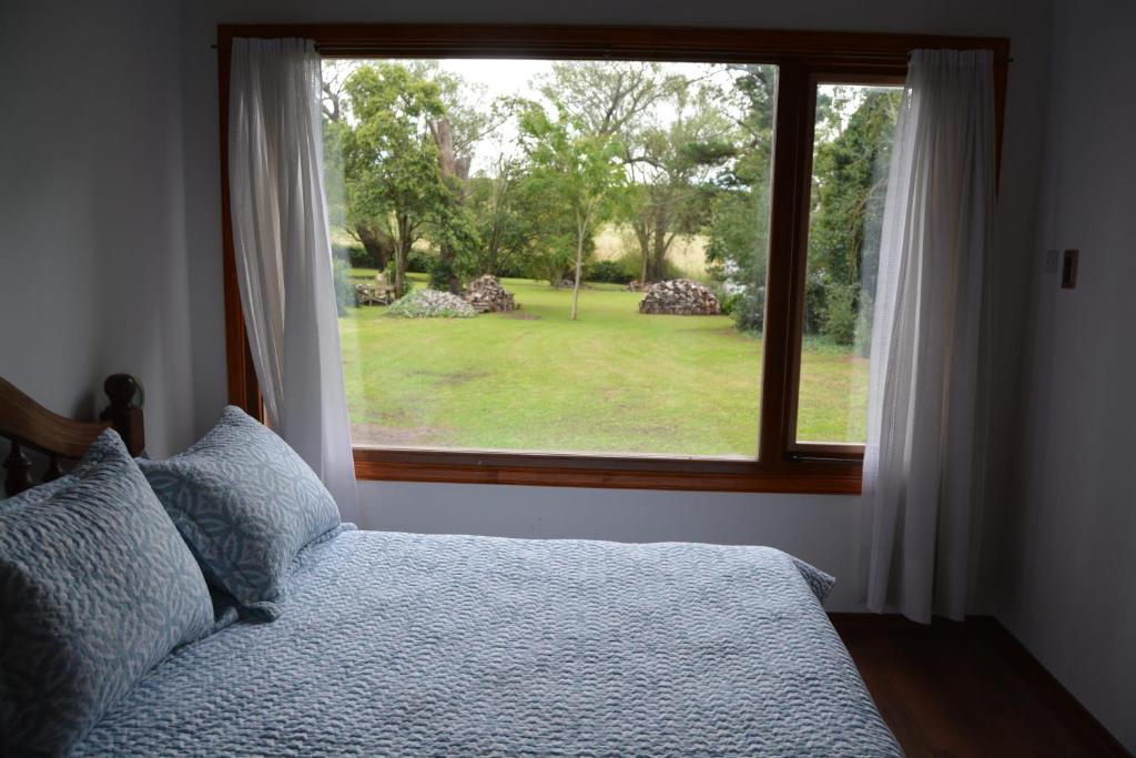 a bedroom with a bed and a large window at Cabaña El Tigre in Tandil