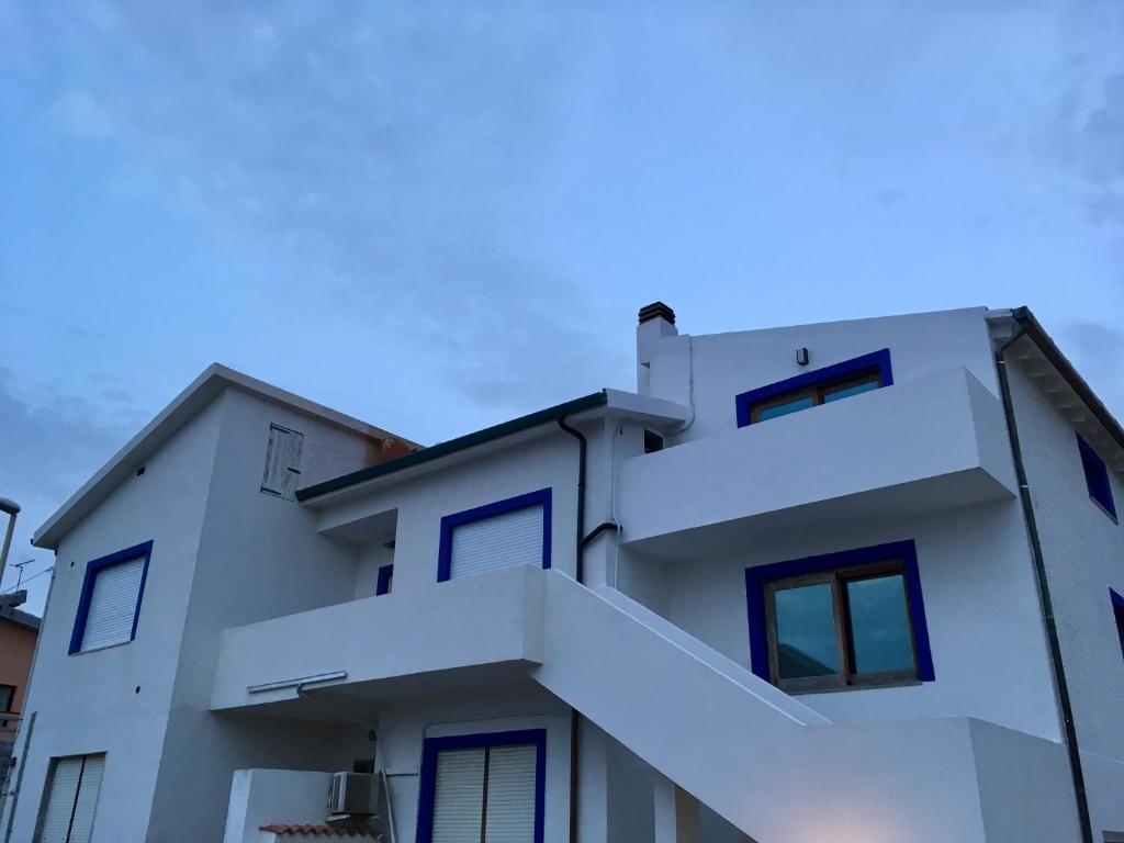 een wit huis met een blauwe lucht op de achtergrond bij B&B BentueMari in Portoscuso