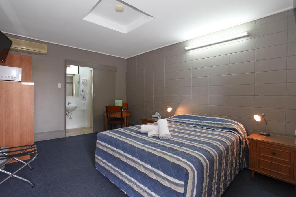 een hotelkamer met een bed en een badkamer bij Tandara Hotel Motel in Sarina