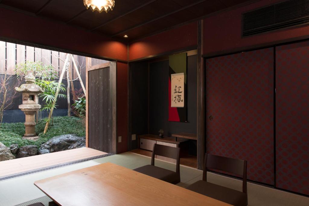 a room with a table and a large window at Kamishichiken Oku in Kyoto