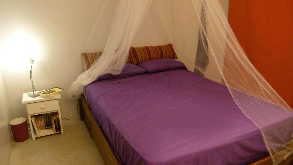 1 dormitorio con cama morada y mosquitera en Casa Marieta Ocean Park, en Sauce de Portezuelo