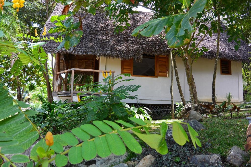 a small house with a thatch roof at Coco Komba Lodge in Nosy Komba