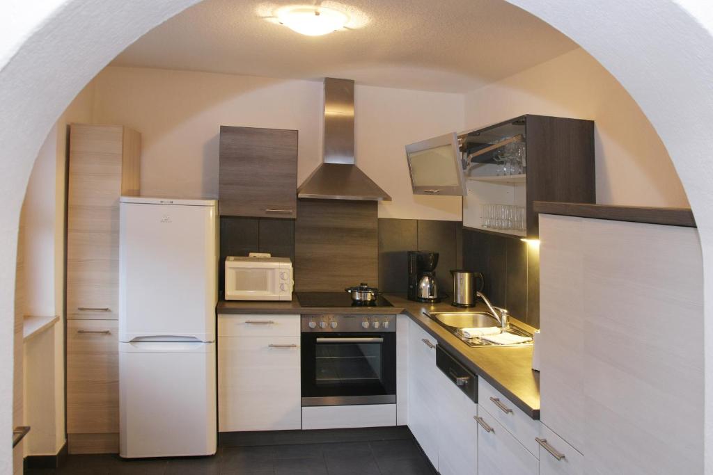 eine Küche mit einem weißen Kühlschrank und einer Mikrowelle in der Unterkunft Villa Holiday Home in Zell am See