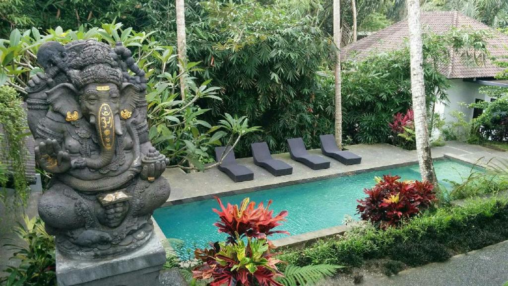 a statue of an elephant next to a swimming pool at The Bali Shanti in Ubud