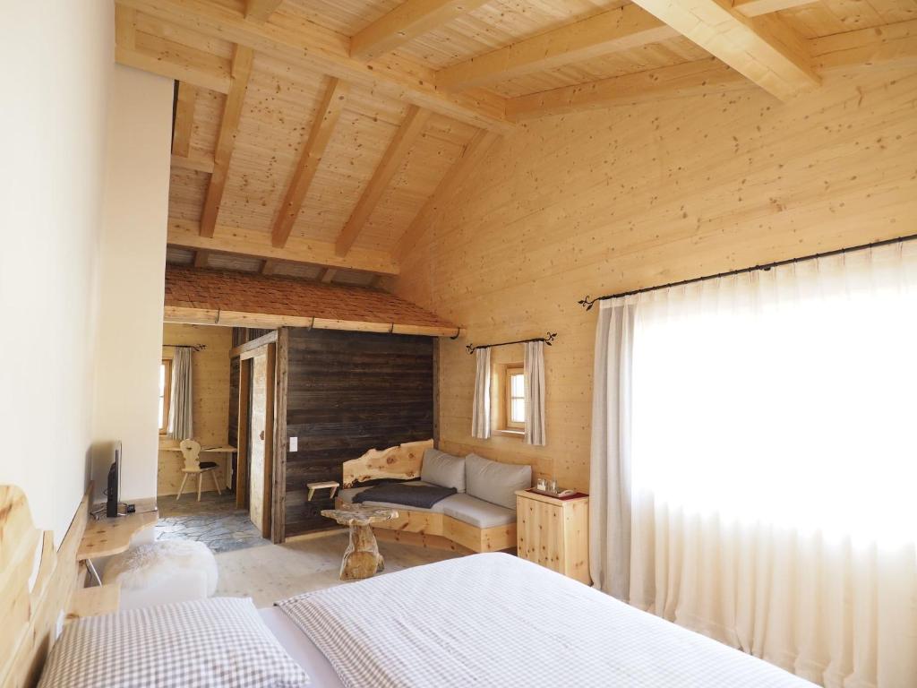 a bedroom with a bed and a couch in a room at Kleines Zirbelhotel - ÜF in Oberammergau