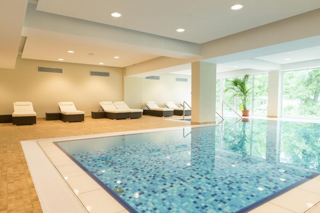 een zwembad in een huis met een woonkamer bij Aribo Hotel in Erbendorf